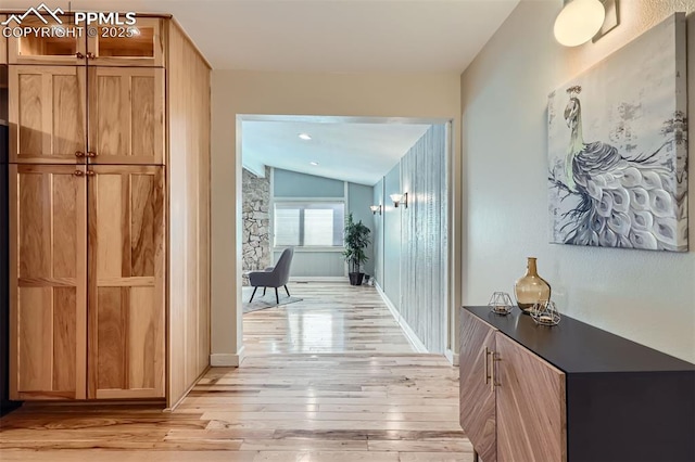 corridor with vaulted ceiling and light hardwood / wood-style floors