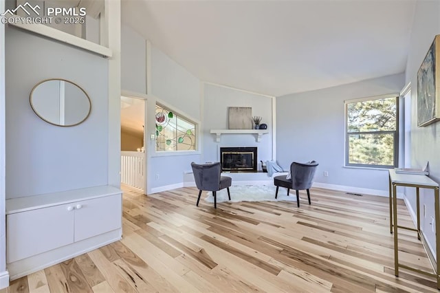 sitting room with vaulted ceiling and light hardwood / wood-style floors