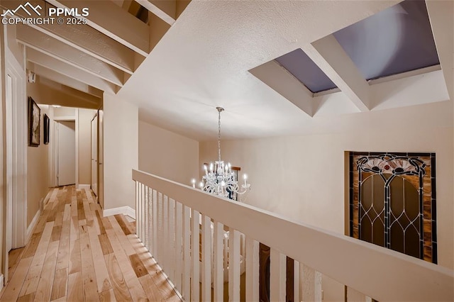 hallway featuring an inviting chandelier and wood-type flooring