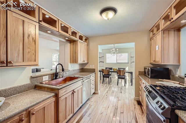 kitchen featuring decorative light fixtures, a wealth of natural light, sink, and stainless steel appliances