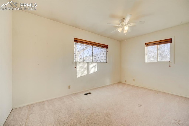 unfurnished room featuring ceiling fan, plenty of natural light, and light colored carpet