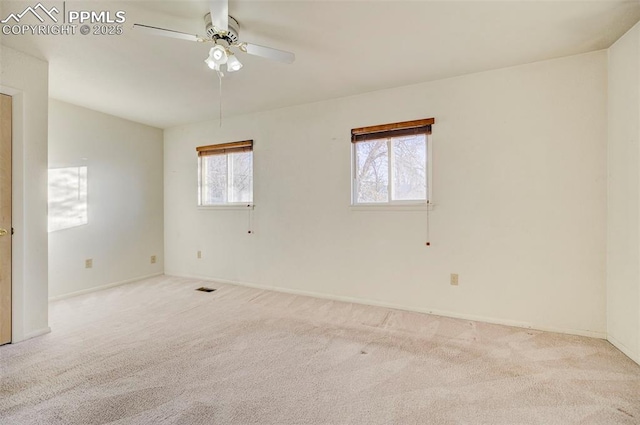 unfurnished room featuring a healthy amount of sunlight, light colored carpet, and ceiling fan