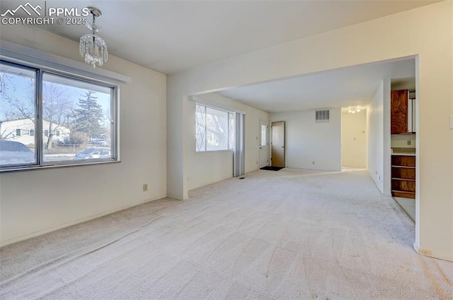 interior space featuring a chandelier and light colored carpet