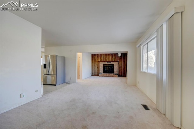 unfurnished living room with a fireplace and light carpet