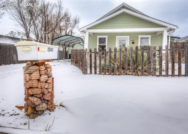 view of snowy exterior with a carport