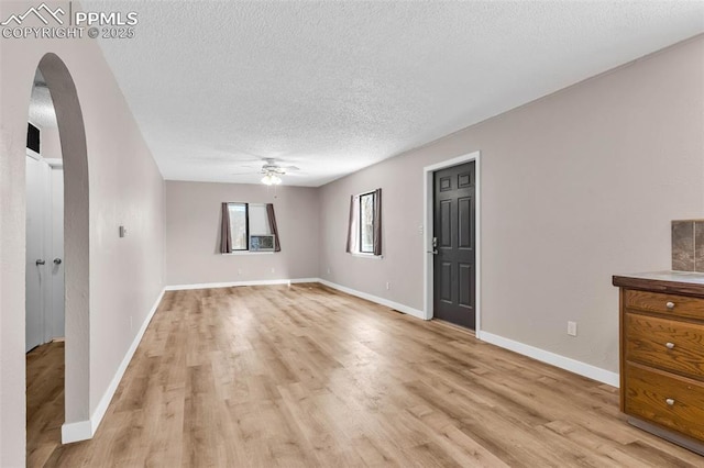 spare room with ceiling fan, light hardwood / wood-style floors, and a textured ceiling