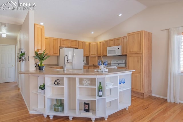 kitchen featuring white appliances, light brown cabinets, kitchen peninsula, vaulted ceiling, and light hardwood / wood-style flooring