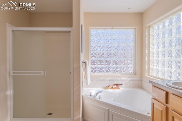 bathroom featuring vanity, a wealth of natural light, and plus walk in shower