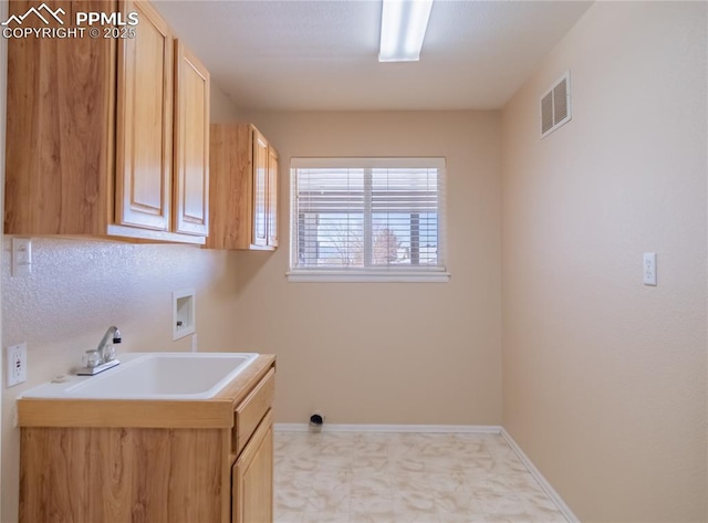 laundry room featuring sink, hookup for a washing machine, and cabinets