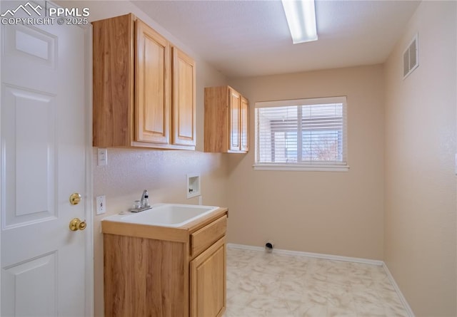 clothes washing area featuring washer hookup, cabinets, and sink