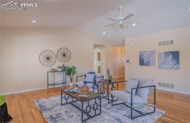 living area featuring ceiling fan, lofted ceiling, and light wood-type flooring