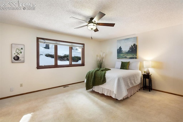 bedroom with light carpet, ceiling fan, and a textured ceiling