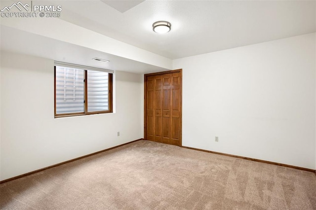 unfurnished room featuring light carpet