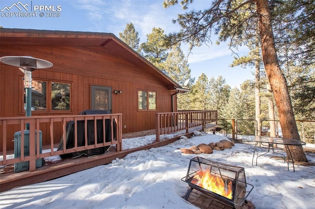 snow covered deck with an outdoor fire pit