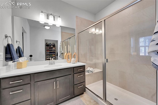 bathroom featuring a shower with shower door and vanity