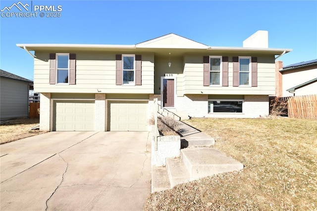 split foyer home with a front yard and a garage