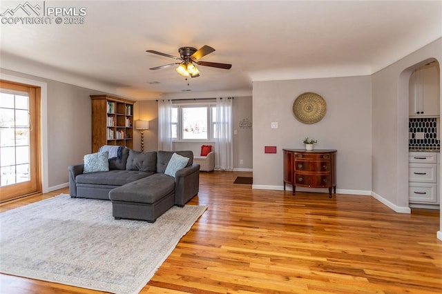 living room with light hardwood / wood-style floors and ceiling fan