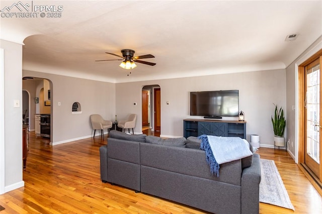 living room featuring ceiling fan and light hardwood / wood-style flooring