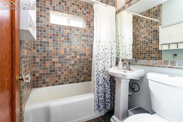 bathroom featuring shower / tub combo and toilet