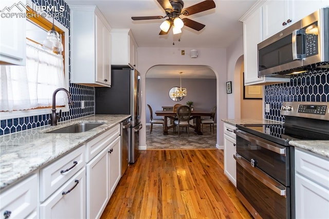 kitchen featuring light wood-type flooring, stainless steel appliances, white cabinets, and sink