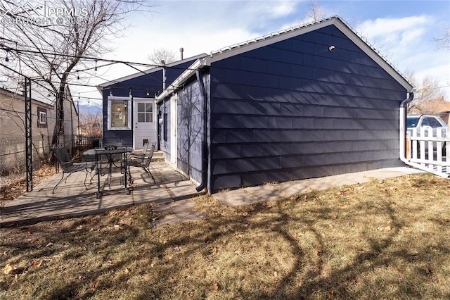 back of house with a yard and a patio