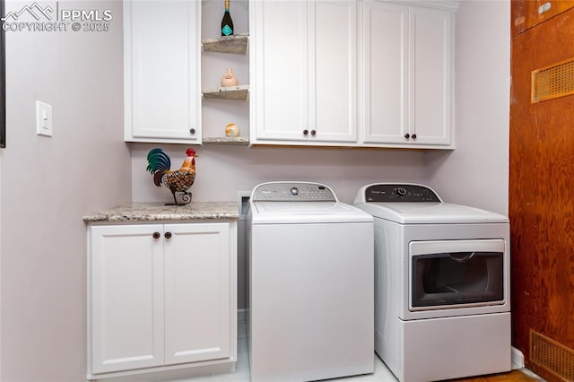 washroom with separate washer and dryer and cabinets