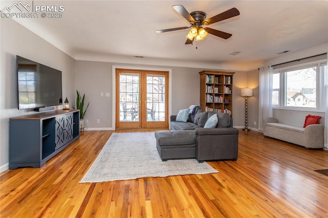 living room with ceiling fan, wood-type flooring, and a wealth of natural light