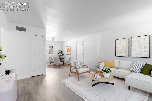 living room featuring ceiling fan and light hardwood / wood-style flooring