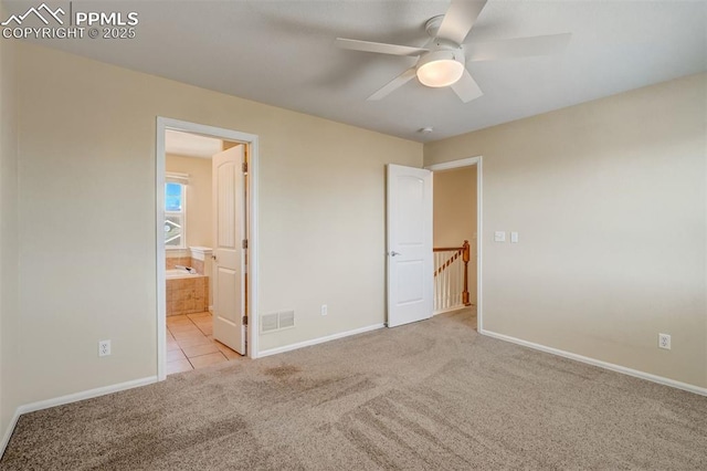 unfurnished bedroom with ensuite bathroom, ceiling fan, and light carpet