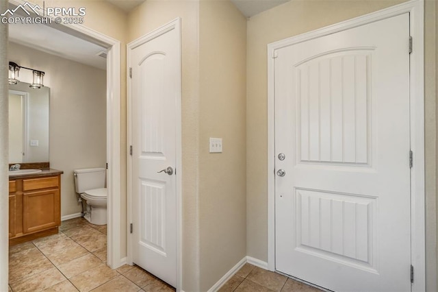 doorway to outside with light tile patterned flooring and sink