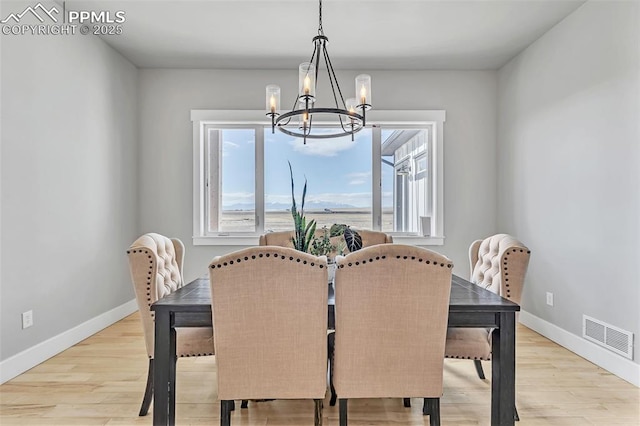 dining room featuring light hardwood / wood-style flooring and a notable chandelier