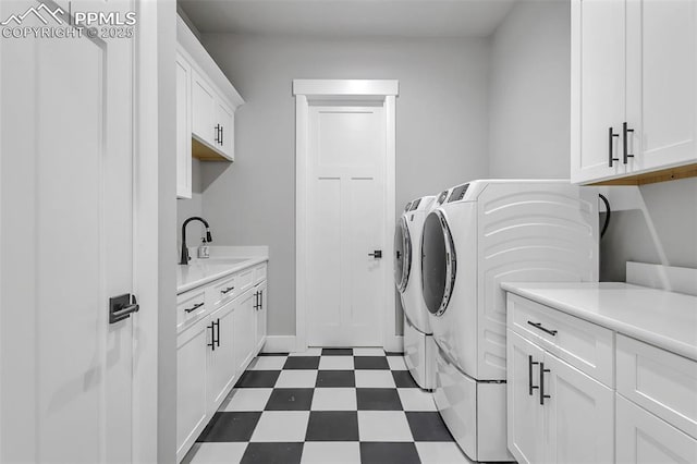 laundry area with sink, washer and dryer, and cabinets