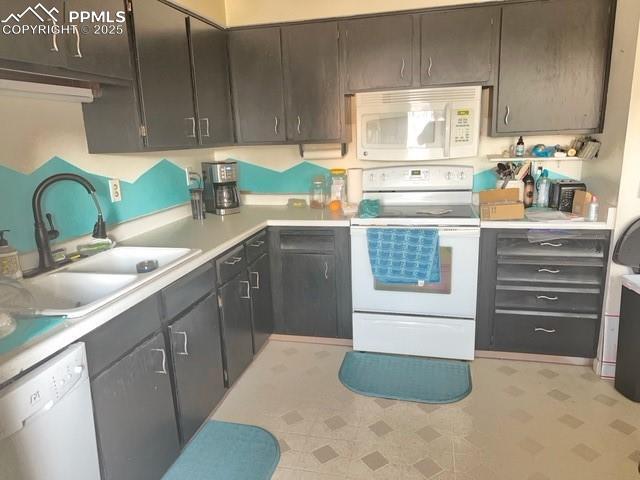 kitchen featuring sink, white appliances, and dark brown cabinets