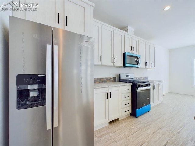 kitchen featuring light stone counters, white cabinetry, and appliances with stainless steel finishes