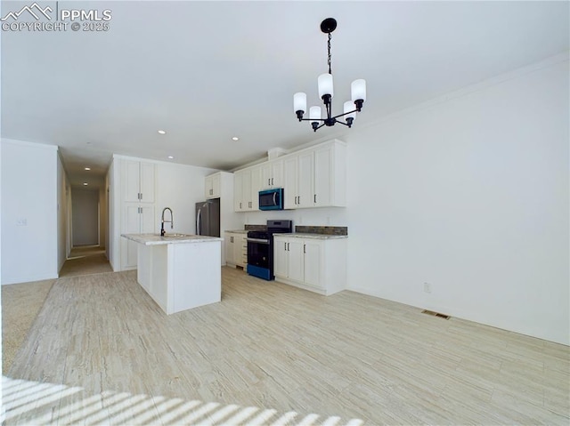 kitchen with pendant lighting, white cabinetry, stainless steel refrigerator, electric range, and a center island with sink