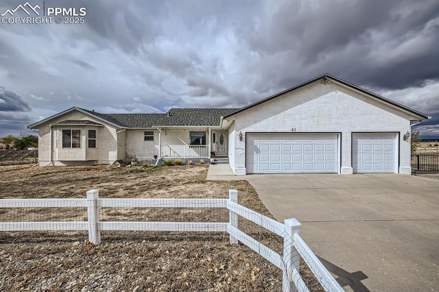 ranch-style home with driveway, a porch, an attached garage, and stucco siding