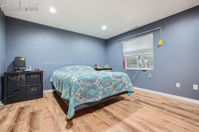 bedroom with light wood finished floors and baseboards