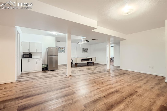 unfurnished living room with light wood-style flooring and baseboards