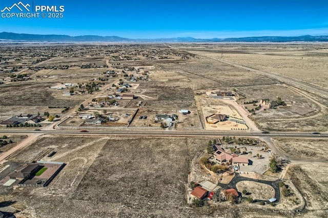 drone / aerial view featuring view of desert and a mountain view