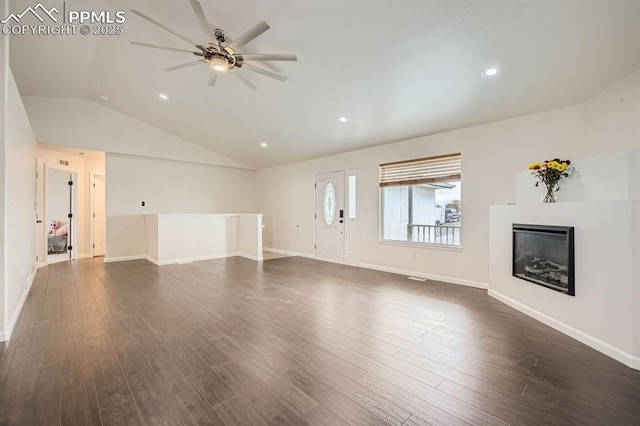 unfurnished living room with ceiling fan, vaulted ceiling, and dark wood-type flooring