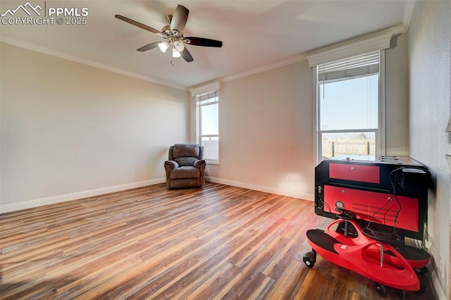 sitting room with ceiling fan, crown molding, and hardwood / wood-style flooring