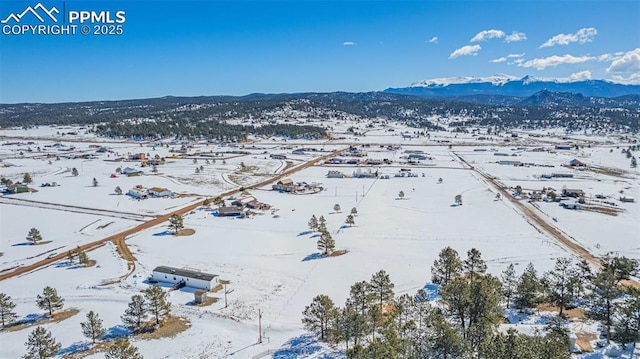 snowy aerial view featuring a mountain view