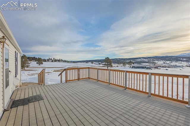 snow covered deck with a mountain view