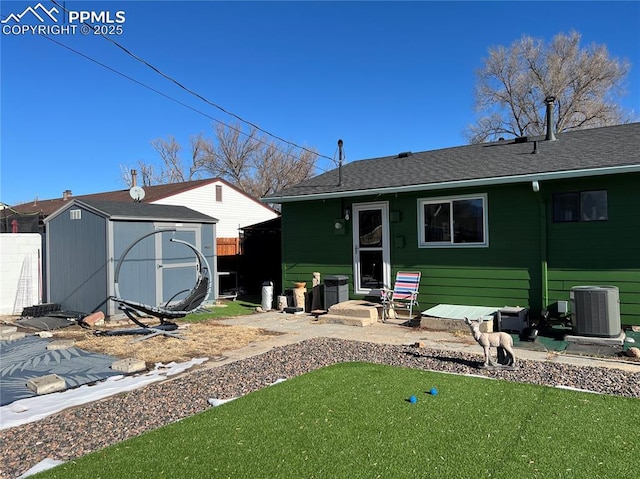 back of house with central AC unit, a storage shed, and a patio