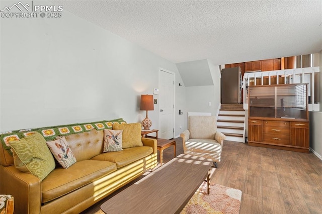 living room with a textured ceiling and light hardwood / wood-style flooring