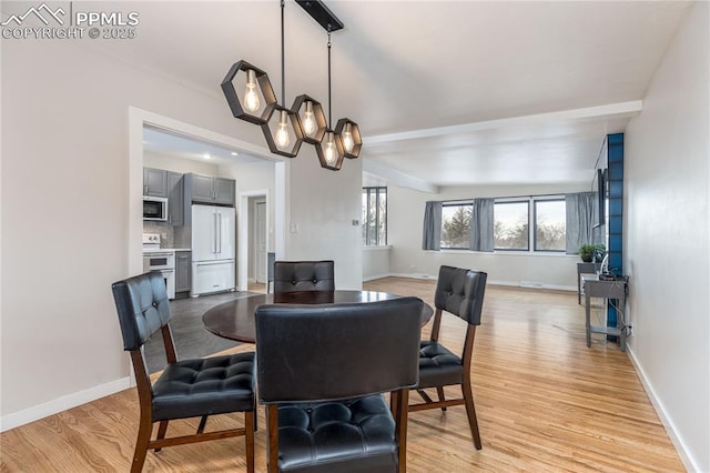 dining space with a notable chandelier and light wood-type flooring