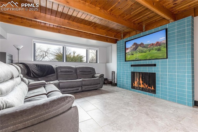 living room with wooden ceiling, a tile fireplace, and beamed ceiling