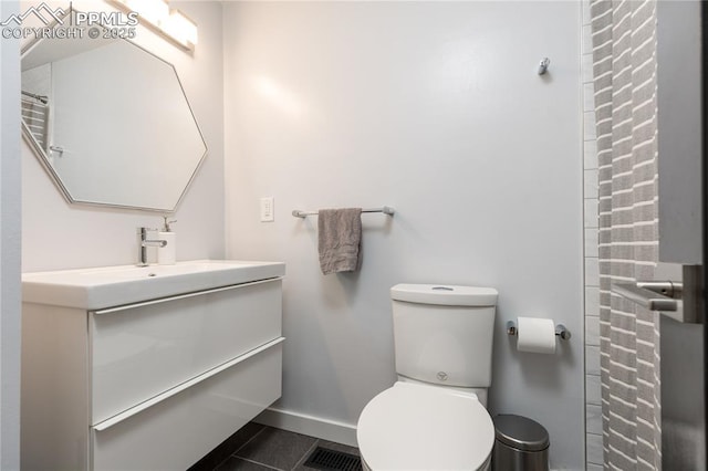 bathroom with toilet, tile patterned floors, and vanity