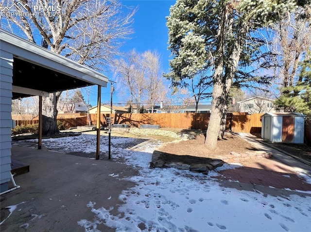 yard covered in snow with a storage shed