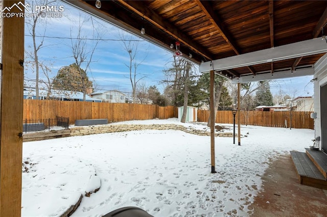 yard layered in snow featuring a storage shed